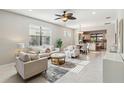 Bright, open living room featuring neutral furniture and decor, leading to the dining area and kitchen at 13864 Posada St, Venice, FL 34293