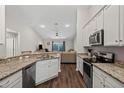 Modern kitchen featuring granite countertops, stainless steel appliances, and wood flooring at 2949 Jaylene Rd, North Port, FL 34288