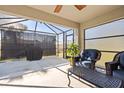 Screened patio area featuring comfortable seating, outdoor decor, and a view of the backyard at 2949 Jaylene Rd, North Port, FL 34288