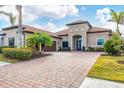 Stunning home showcasing beautiful landscaping, paver driveway, and charming architectural details at 400 Maraviya Blvd, Nokomis, FL 34275