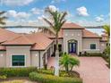 Stunning waterfront home featuring a terracotta roof and elegant double door entry at 400 Maraviya Blvd, Nokomis, FL 34275