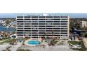 Expansive beachfront condo featuring a community pool, lounge area, well-manicured landscaping, and beach access at 840 The Esplanade N # 104, Venice, FL 34285