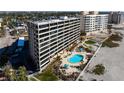 Beautiful condo with a community pool and landscaping, adjacent to the beach, palm trees, and lounge area at 840 The Esplanade N # 104, Venice, FL 34285