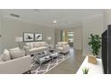 Bright living room with neutral decor, modern furnishings, and a sliding glass door leading to a scenic outdoor space at 9895 Wingood Dr, Venice, FL 34292