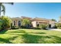 Beautiful single-story home featuring a well-manicured lawn and a two-car garage at 107 Corte Del Rosa, Venice, FL 34285