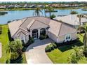Beautiful home with a tile roof, lush landscaping, and a tranquil waterfront location at 1374 Brenner Park Dr, Venice, FL 34292