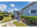 Exterior view featuring the entrance, landscaping, and screened porch at 3300 Loveland Blvd # 1504, Punta Gorda, FL 33980
