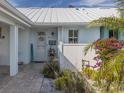 Charming front entrance with white picket fence and lush tropical foliage create inviting curb appeal at 335 Englewood Isles Pkwy # 55, Englewood, FL 34223