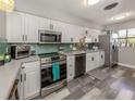 Charming kitchen featuring white cabinets, stainless steel appliances, and modern countertops at 335 Englewood Isles Pkwy # 55, Englewood, FL 34223