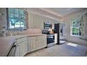 Bright kitchen featuring stainless steel appliances, white cabinets, and a view from the window at 900 Paisley Ct # 1, Venice, FL 34293