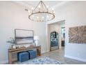 Elegant entryway featuring a console table, mirror, art, and a view into the kitchen at 11571 Gleaming Ter, Venice, FL 34293