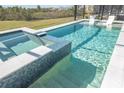 Sparkling pool with an integrated spa and two chairs inside the pool at 11571 Gleaming Ter, Venice, FL 34293