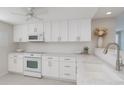 Bright kitchen features white cabinets, countertops, microwave and electric range at 627 Alhambra Rd # 601, Venice, FL 34285