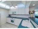 Bright kitchen features white cabinets, countertops, microwave and electric range at 627 Alhambra Rd # 601, Venice, FL 34285