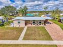 An aerial view of a cozy home with a brick driveway, green lawn, and canal front location at 6627 Marius Rd, North Port, FL 34287