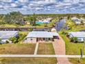 Aerial view of a charming single-story home with canal access, brick driveway and adjacent screened in pool at 6627 Marius Rd, North Port, FL 34287