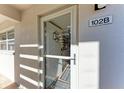 Bright condo entrance with a storm door and unit number 102B at 110 Vista Hermosa Cir # 102B, Sarasota, FL 34242