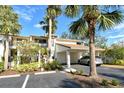 Well-maintained condo featuring a covered parking area surrounded by mature palm trees at 1106 Bird Bay Way # 316, Venice, FL 34285