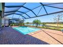 Sparkling pool area with screened enclosure overlooking a serene lake view at 14724 Ponce De Leon Trl, Port Charlotte, FL 33981