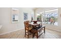 Cozy dining area features a wooden table, bench, and scenic views of the pool at 133 Treviso Ct, North Venice, FL 34275