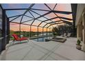 Relaxing screened-in pool with lounge chairs and lake views provides a perfect oasis at 133 Treviso Ct, North Venice, FL 34275