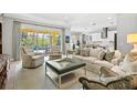 Open-concept living area with a pool view, neutral tones, and bright kitchen at 19832 Bridgetown Loop, Venice, FL 34293