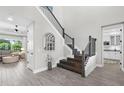 Bright foyer with hardwood floors, staircase, and an arched window providing natural light at 19836 Bridgetown Loop, Venice, FL 34293