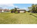 Inviting single-story home with lush green lawn and vibrant tropical landscaping at 407 Rubens Dr, Nokomis, FL 34275