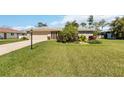 Charming single-story home featuring a well-manicured lawn and mature landscaping at 407 Rubens Dr, Nokomis, FL 34275