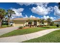 Inviting one-story home with well-maintained lawn, mature palms, and paved walkway at 408 Otter Creek Dr, Venice, FL 34292