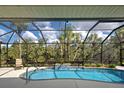 Screened pool with fountain feature offers a serene and private backyard retreat surrounded by lush greenery at 408 Otter Creek Dr, Venice, FL 34292