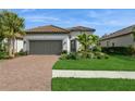 Beautiful single-story home with lush landscaping, healthy green lawn and a paver driveway at 5665 Piccolo St, Nokomis, FL 34275