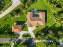 Aerial view of the home's roof, manicured lawn, circular driveway, and separate garage building at 5694 Hale Rd, Venice, FL 34293