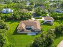Back of home featuring screen enclosed pool and large manicured backyard on a verdant private lot at 5694 Hale Rd, Venice, FL 34293