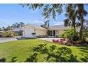 Charming single-story home with a well-manicured lawn, mature trees and attached two-car garage at 888 Guild Dr, Venice, FL 34285