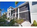 Beautiful exterior shot of the building with screened balconies and lush landscaping, perfect for outdoor living at 12580 Galapagos Ct # 107, Venice, FL 34293