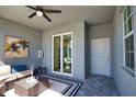 This is a beautiful screened patio with a ceiling fan, a cozy couch, and an outdoor rug and table at 12580 Galapagos Ct # 107, Venice, FL 34293