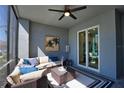 This is a beautiful screened patio with a ceiling fan, a cozy couch, and an outdoor rug and table at 12580 Galapagos Ct # 107, Venice, FL 34293