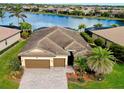 An aerial view of a single-Gathering home overlooking a large lake with surrounding homes and landscaping at 13238 Famiglia Dr, Venice, FL 34293