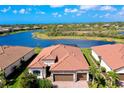 Aerial view of a beautiful tile roof home with a large lake in the backyard at 13730 Vancanza, Venice, FL 34293