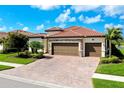 Beautiful home with a three-car garage and well-maintained landscaping and brick driveway at 13730 Vancanza, Venice, FL 34293