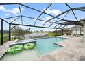 Stunning pool with a screened enclosure and beautiful lake view with plenty of seating at 21248 Holmes Cir, Venice, FL 34293