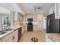 Open kitchen design with white cabinetry, granite counters, stainless appliances, and stylish tile flooring at 225 Randolph Rd, Venice, FL 34293