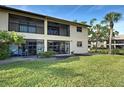 A spacious patio offers a peaceful outdoor retreat with lush green grass leading down to a tranquil pond at 345 Three Lakes Ln # L, Venice, FL 34285