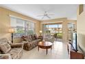 Bright living room with tile floors, ceiling fan and a sliding door to a patio with lake view at 4210 Vicenza Dr # A25, Venice, FL 34293