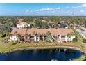 Aerial view of condo with water view, balcony, and mature landscaping, in a well-maintained community at 630 Bird Bay E Dr # 208, Venice, FL 34285