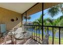 Enjoy this screened balcony view with a table and seating overlooking a pond at 630 Bird Bay E Dr # 208, Venice, FL 34285