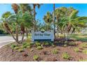 Welcoming community sign for Bird Bay Village surrounded by lush tropical landscaping and mature palm trees at 630 Bird Bay E Dr # 208, Venice, FL 34285