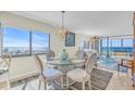 Inviting dining area with views of the beach and a modern chandelier above a glass table at 840 The Esplanade N # 301, Venice, FL 34285