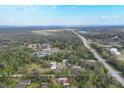 Aerial view shows the boundaries of a property with a pond and rural structures amongst dense trees and foliage at 964 1St Dirt Rd, Venice, FL 34292